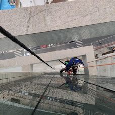 Limpeza de fachada de vidro com acesso por corda